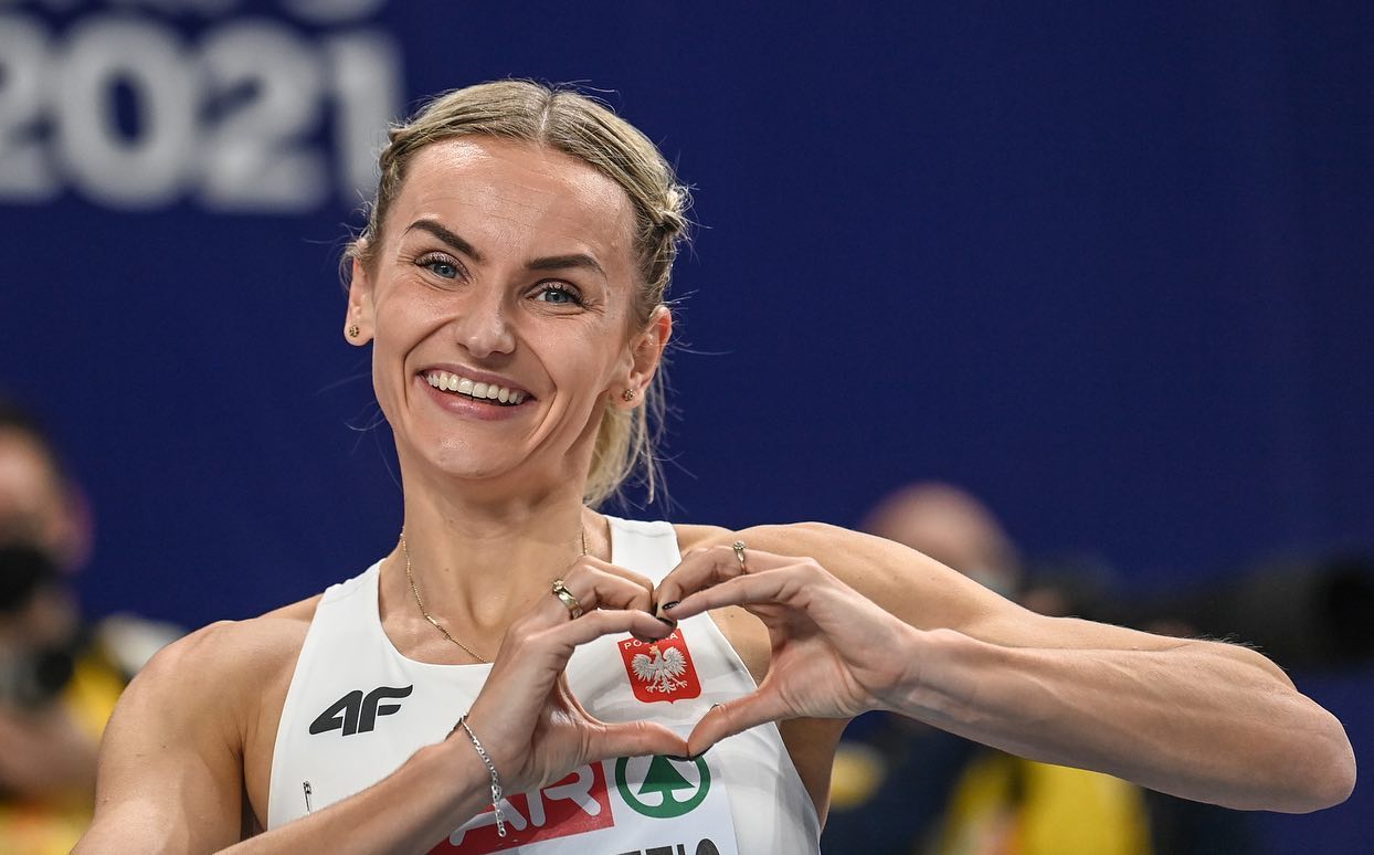 Zdjęcie przedstawia kobietę pokazującą serce z palców u dłoni