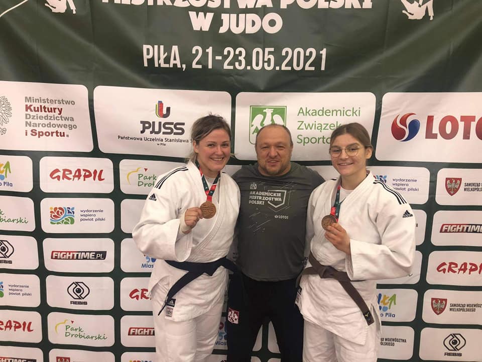 Zdjęcie przedstawia trójkę ludzi uśmiechających się