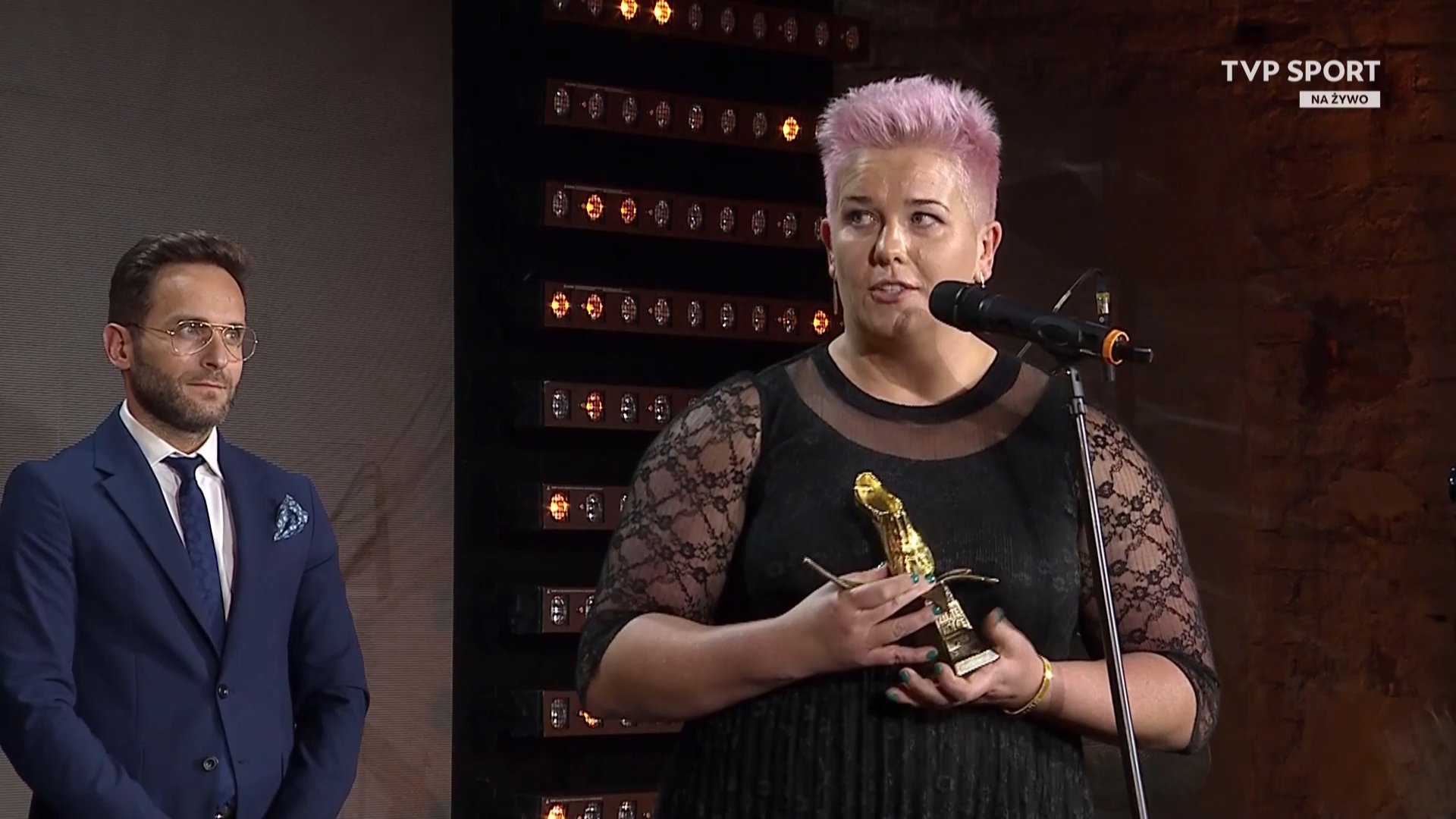 Zdjęcie przedstawia kobietę odbierającą nagrodę "złote kolce"