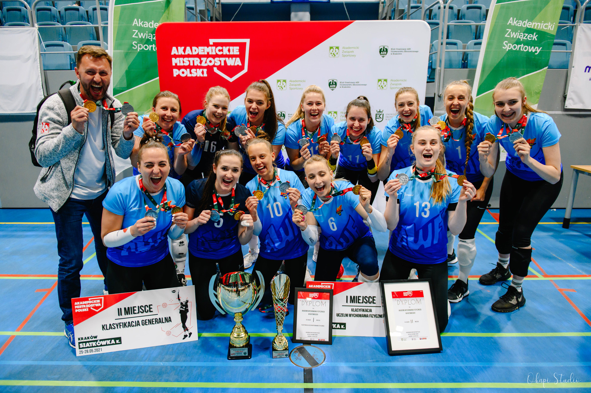 Zdjęcie przedstawia grupę ludzi uśmiechających się trzymając medale