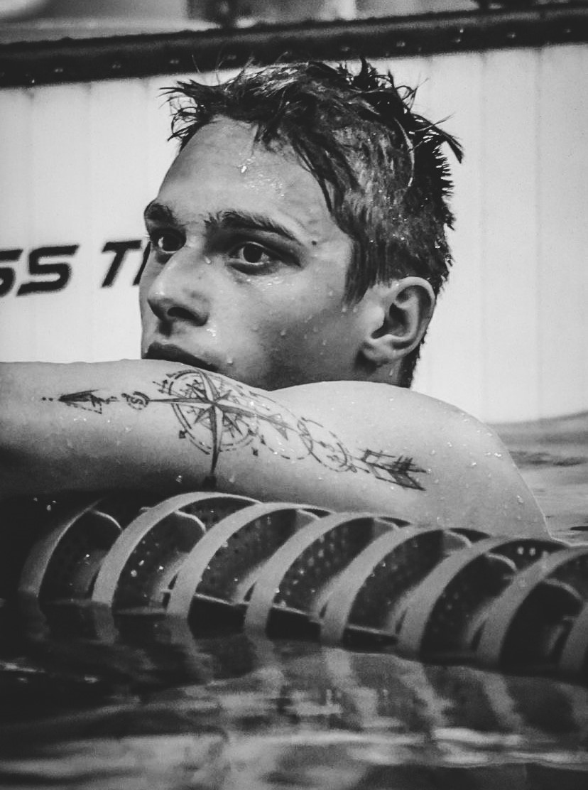 Czarno-białe zdjęcie przedstawia mężczyznę w basenie