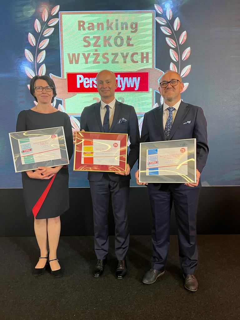 Zdjęcie przedstawia trzy osoby uśmiechające się trzymające nagrody