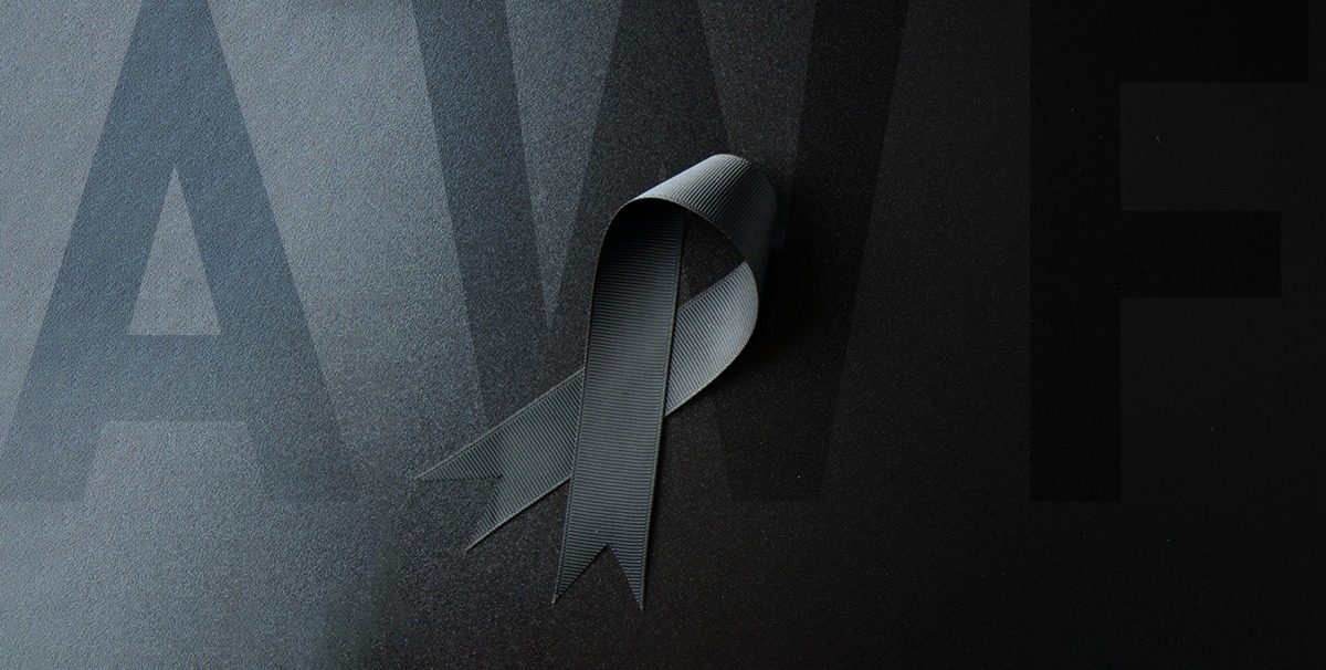 napis AWF na tle przechodzącym z bieli do czerni, po środku czarna wstążka