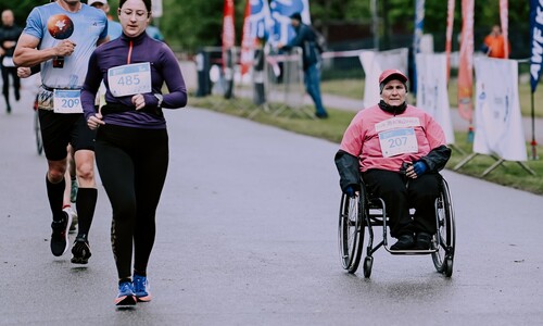 biegacz i uczestniczka na w&oacute;zku inwalidzkim
