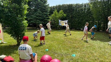  Dzieci bawią się na podw&oacute;rku, grając w piłki i biegając wesoło