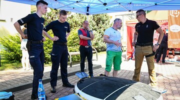 dr Jacek Polechoński z uczestnikami wydarzenia omawiający urządzenie VR