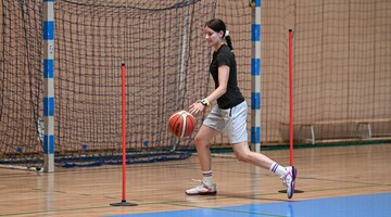 uczestniczka kursu w trakcie biegu slalomem z piłką do koszyk&oacute;wki