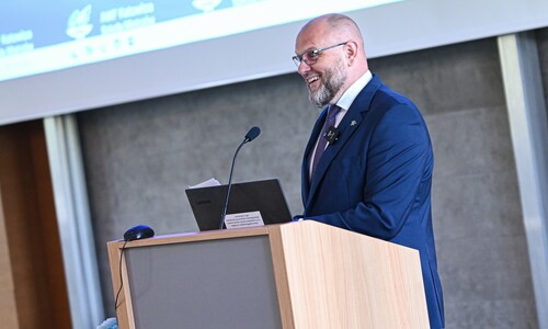 Prorektor Andrzej Myśliwiec stoi przy m&oacute;wnicy, wygłaszając przem&oacute;wienie.