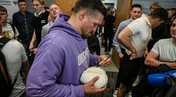 Oleksander Usyk dajacy autograf na ekawicy bokserskiej