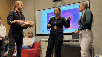 Warsztaty z zajęć pierwsza pomoc z elementami samoobrony, dr Dominika Grzybowska Ganszczyk tłumacząca zasady udzielania pierwszej pomocy niemowlętom